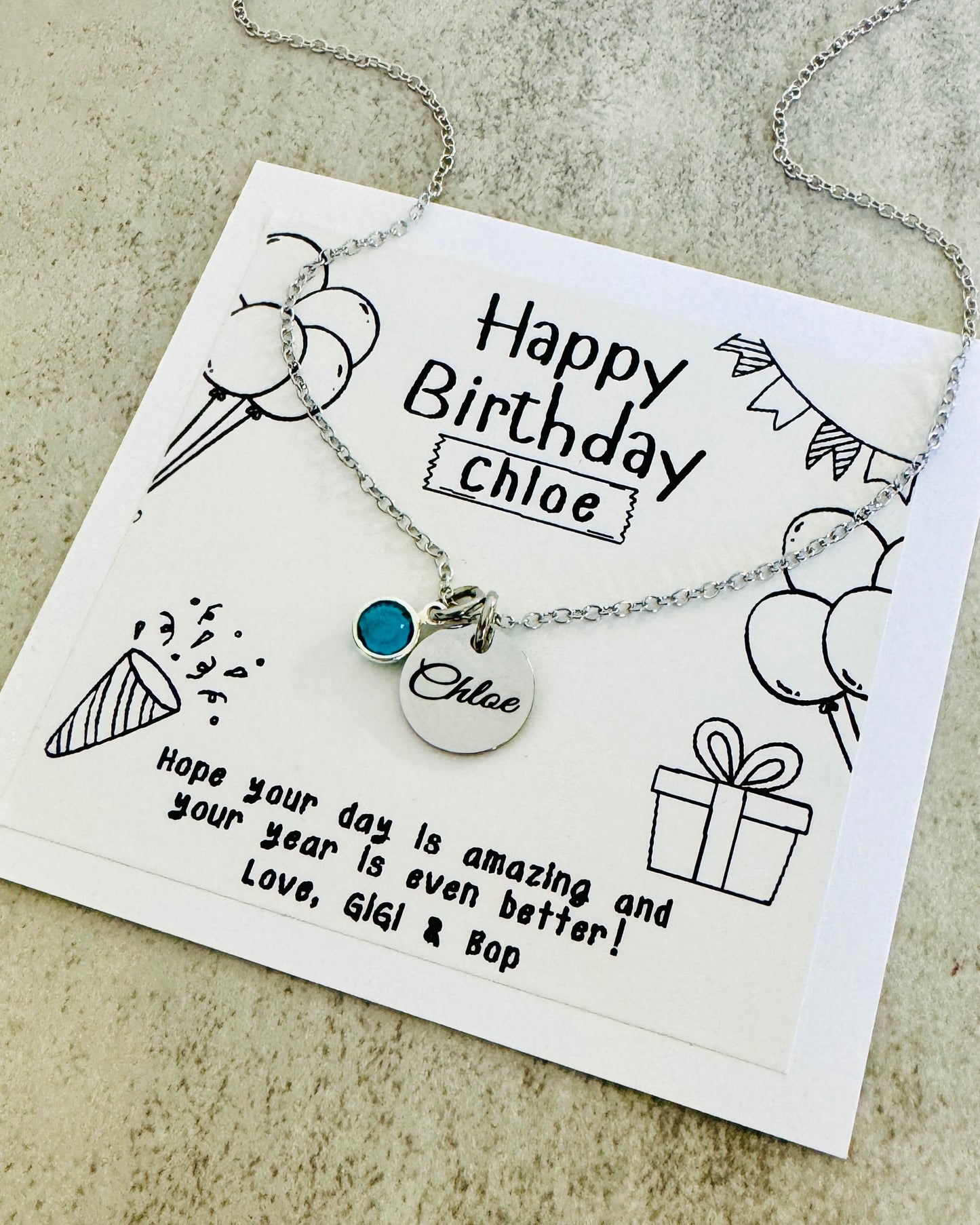 silver necklace with birthstone charm engraved with a name or custom text. personalized birthday card included for gift