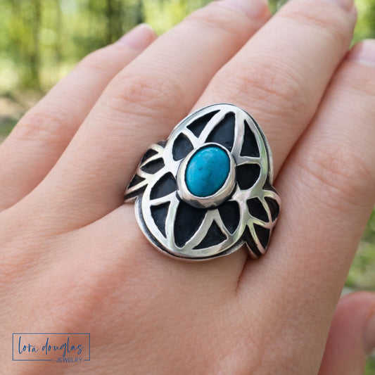 turquoise and sterling silver ring size 8.5 on a hand, logo for 'Lora Douglas Jewelry' visible
