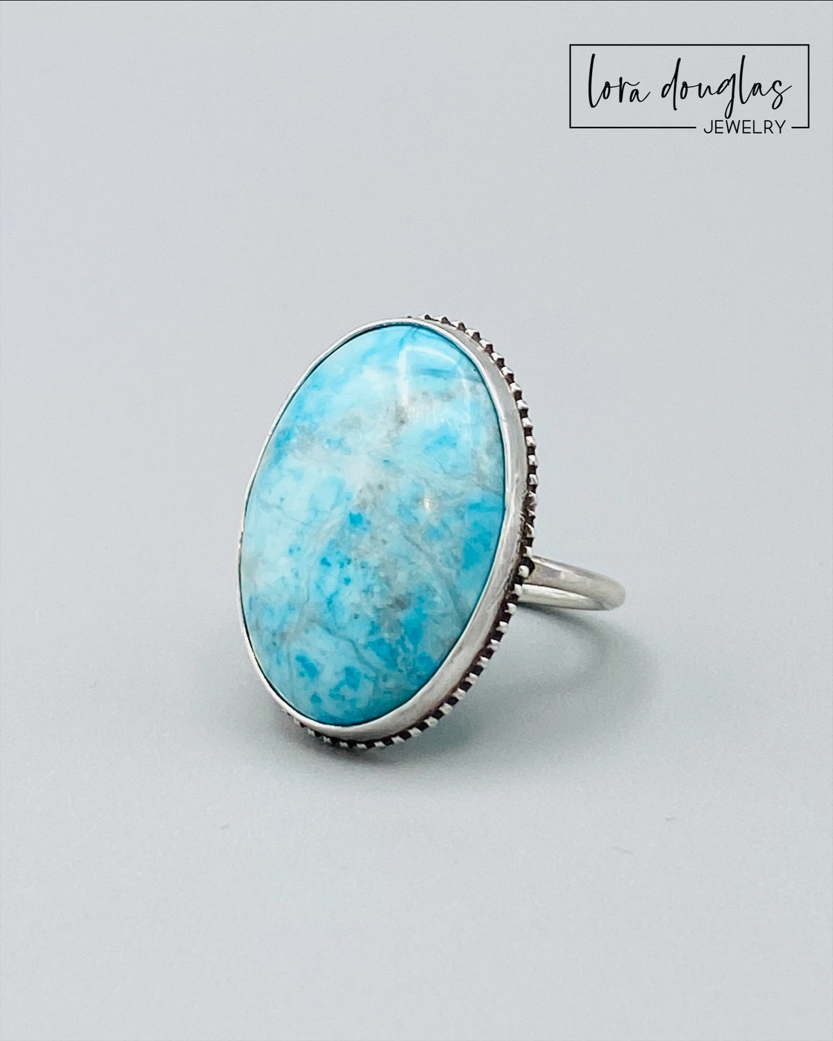 Blue gemstone statement ring featuring a substantial natural turquoise stone measuring 26mm x 19mm and set in sterling silver, shown in US size 7 for shoppers seeking bold turquoise and natural stone jewelry.
