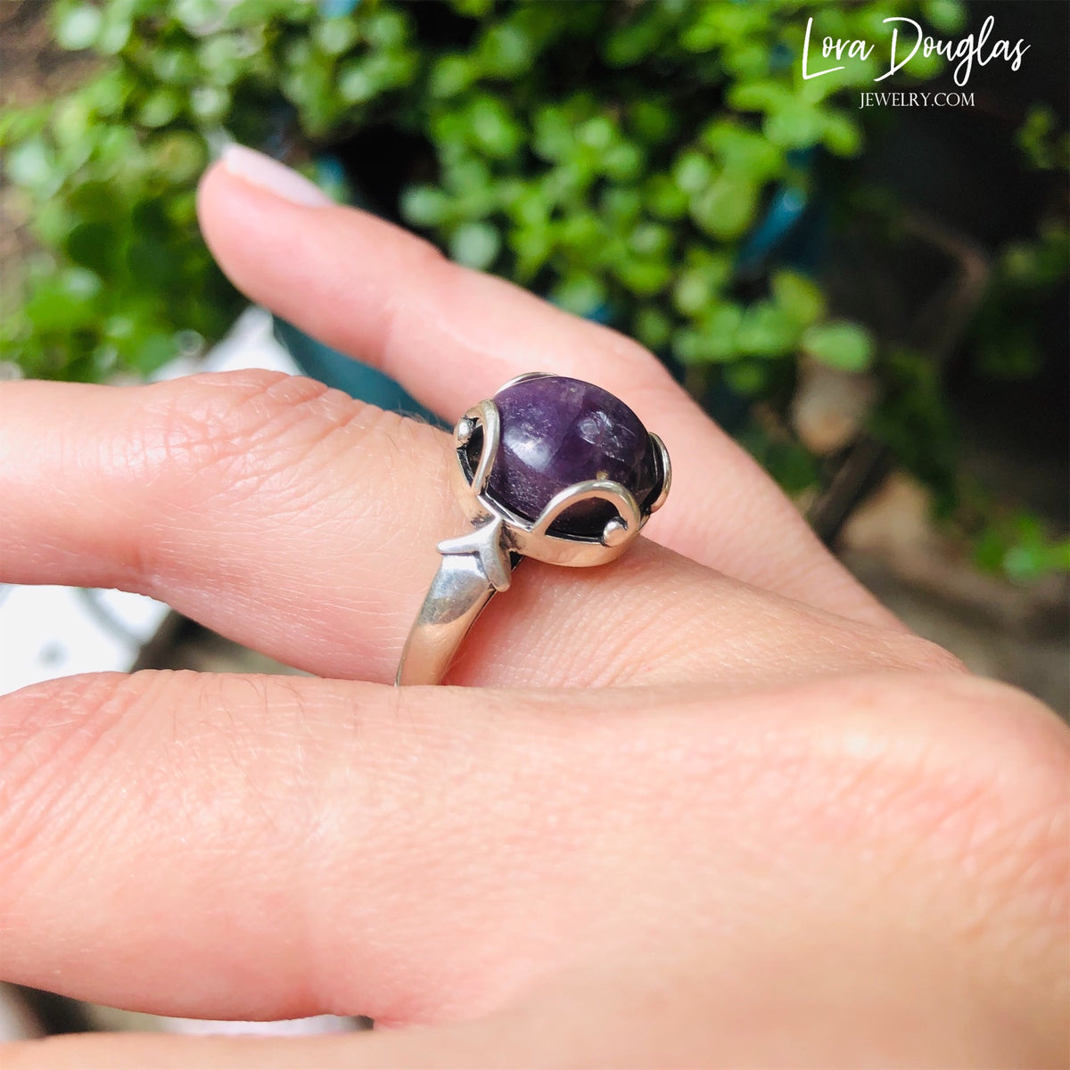 Close view of a Purple India Ruby ring showing the natural color and character of the 12mm stone against genuine 925 sterling silver, a finished US size 7 gemstone ring and July birthstone jewelry option.
