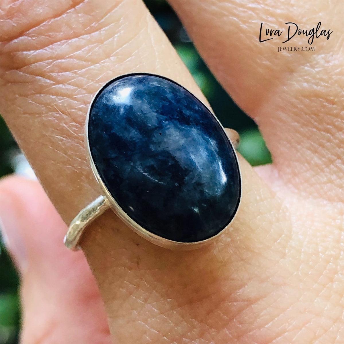 Close view of a handcrafted sodalite ring showing the rich blue color and natural variation of the 18mm x 13mm gemstone, framed in sterling and fine silver and finished in US ring size 8.75.
