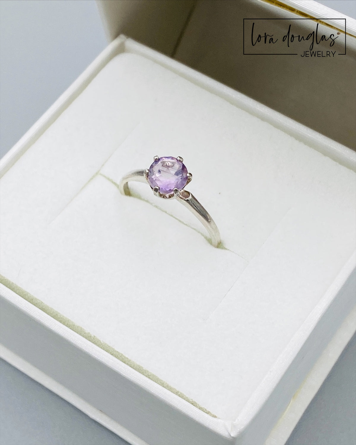 Detailed view of a 6mm pink amethyst gemstone showing its delicate lavender pink coloring, set in sterling silver as a finished size 6.5 solitaire ring for shoppers who love subtle amethyst jewelry.
