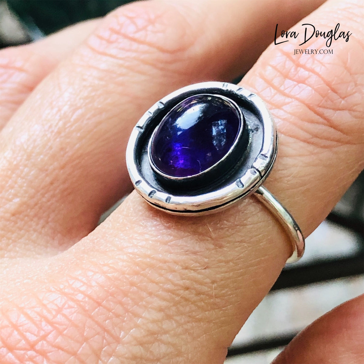 Detailed view of a natural amethyst gemstone measuring 12mm x 10mm within a sterling and fine silver shadow box setting, highlighting the dimensional design of this handcrafted size 7.5 ring.
