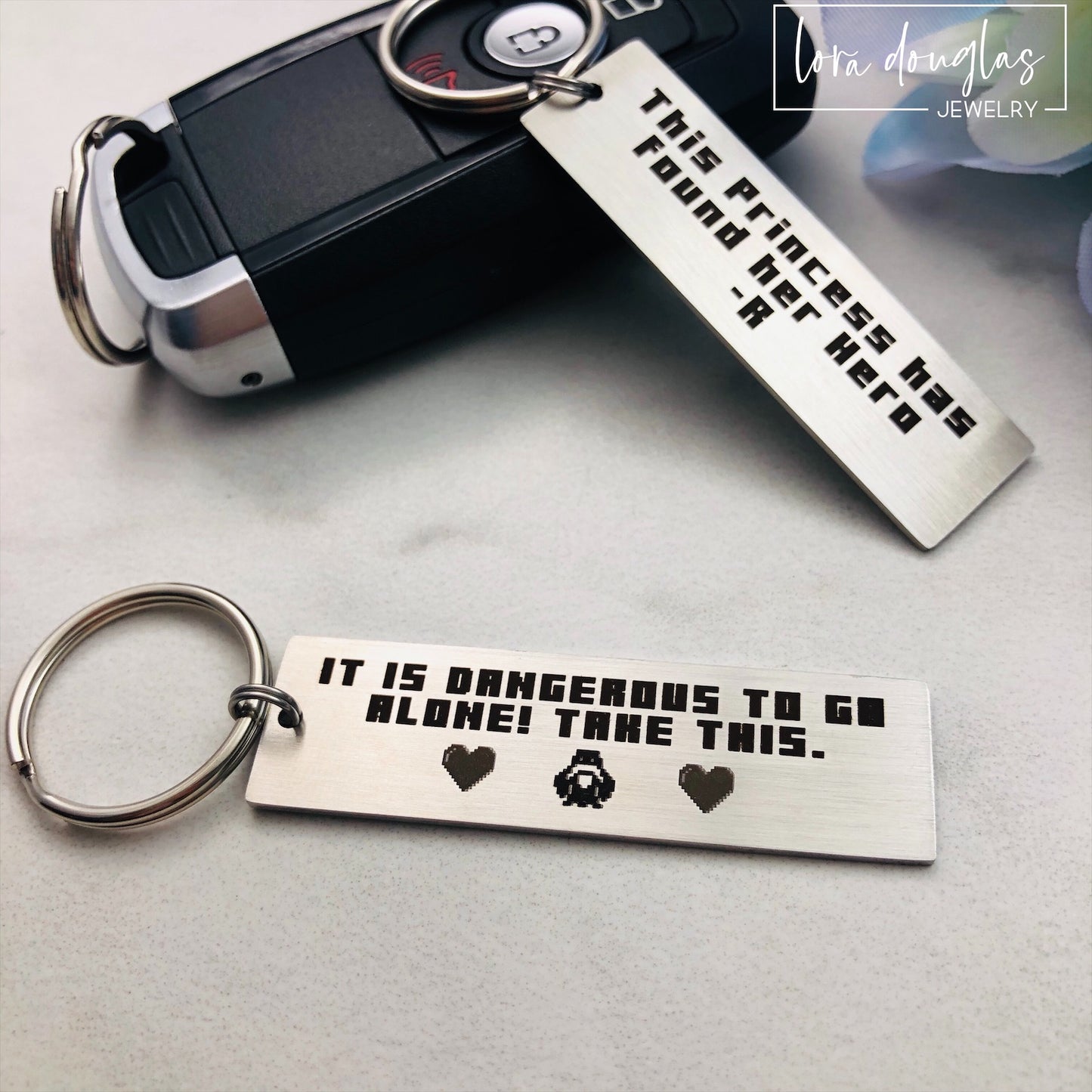 Engraved stainless steel Legend of Zelda keychain featuring retro pixel artwork inspired by the classic video game quote "It is dangerous to go alone. Take this." Personalized gamer gift with optional back engraving for boyfriends, girlfriends, spouses, and Zelda fans.