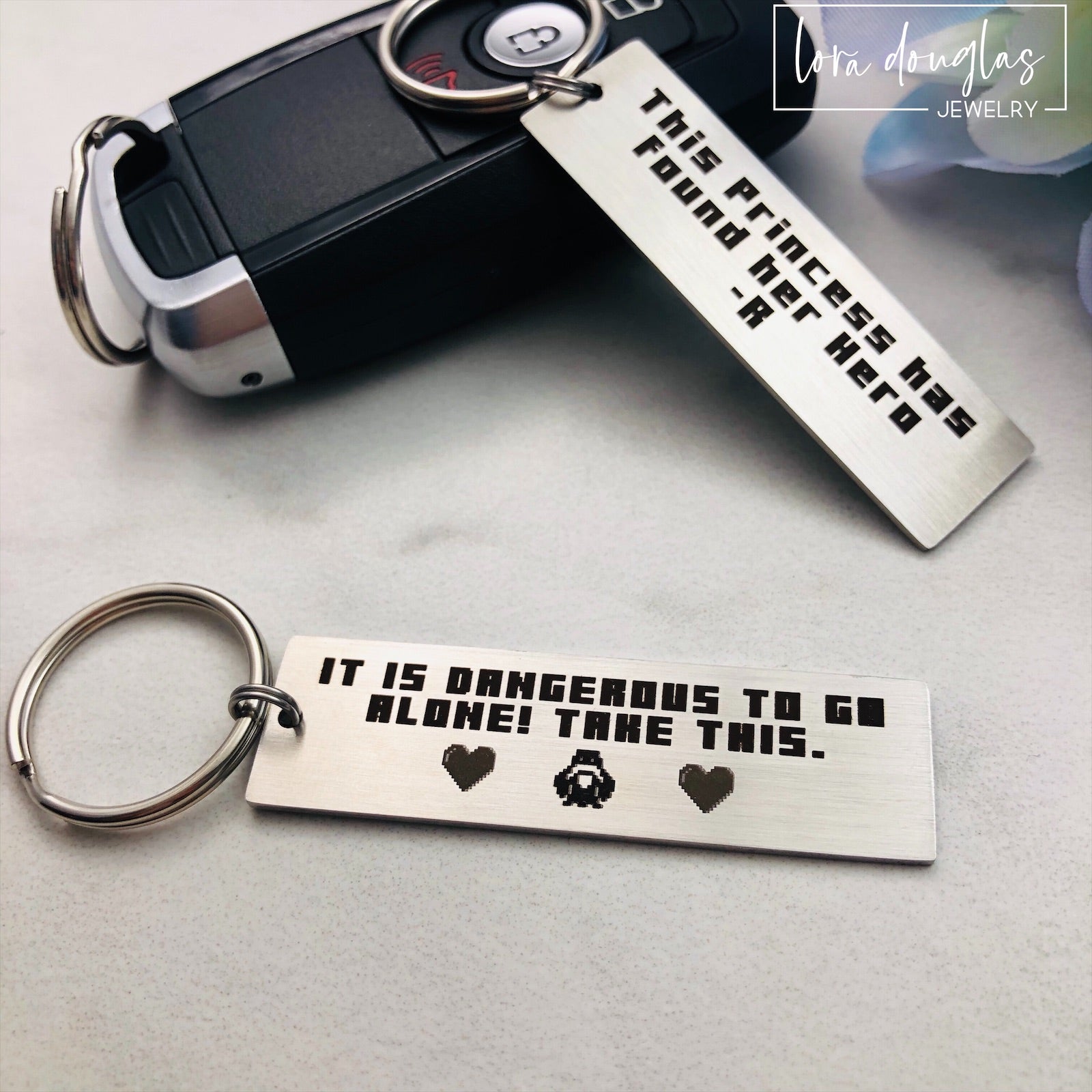 Engraved stainless steel Legend of Zelda keychain featuring retro pixel artwork inspired by the classic video game quote "It is dangerous to go alone. Take this." Personalized gamer gift with optional back engraving for boyfriends, girlfriends, spouses, and Zelda fans.