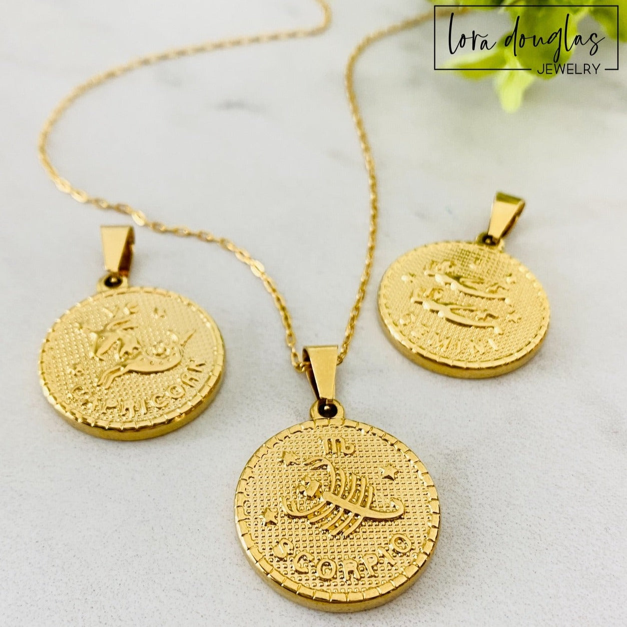 Flat lay of a gold stainless steel Constellation Necklace featuring a zodiac constellation pendant engraved with celestial stars. Meaningful astrology jewelry designed as a birthday gift or everyday necklace.