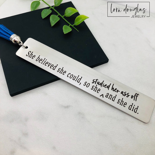 Funny stainless steel bookmark engraved with the quote "She Believed She Could So Studied Her Ass Off And She Did." Motivational gift for graduates, college students, nursing students, law students, medical students, and book lovers.