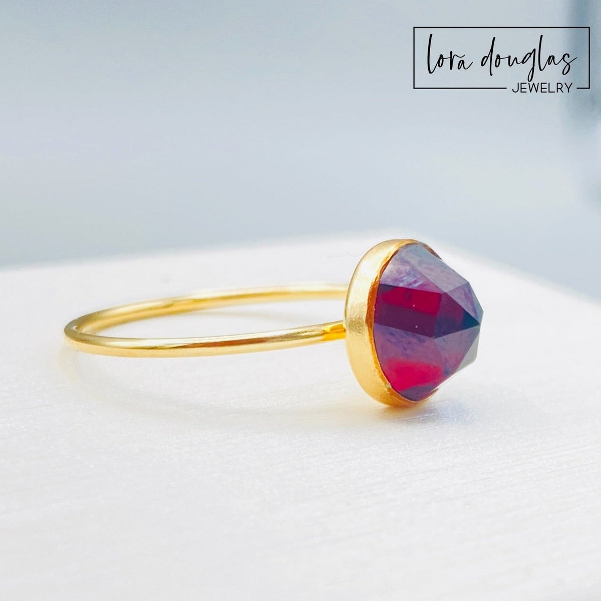 Gold filled garnet ring featuring an 8mm rose cut gemstone with a faceted surface that catches the light, shown in US size 7 as a January birthstone ring or meaningful second anniversary jewelry gift.
