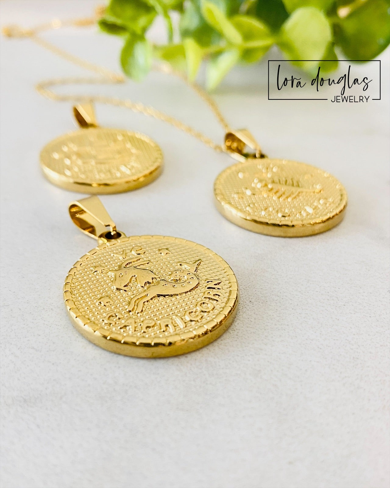 Gold zodiac pendant necklace crafted from stainless steel with engraved constellation artwork. This Constellation Necklace hangs from a 24 inch chain and makes a thoughtful astrology inspired gift.