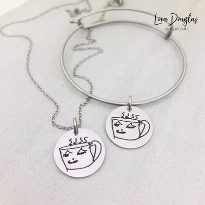Kids drawing keepsake jewelry with a child's artwork engraved onto a round stainless steel disc, available in five pendant sizes and three metal colors for a personalized Mother's Day, Father's Day, birthday, or Christmas gift.