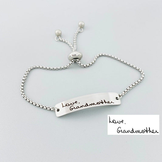 Adjustable stainless steel bracelet engraved with a handwritten message.