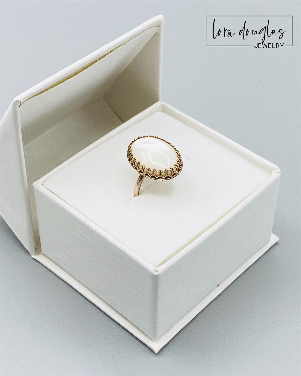 Mother of Pearl and bronze ring in a US size 6 with an 18 x 13 mm natural shell stone. The warm bronze setting contrasts with the luminous iridescent surface for a distinctive artisan statement ring.