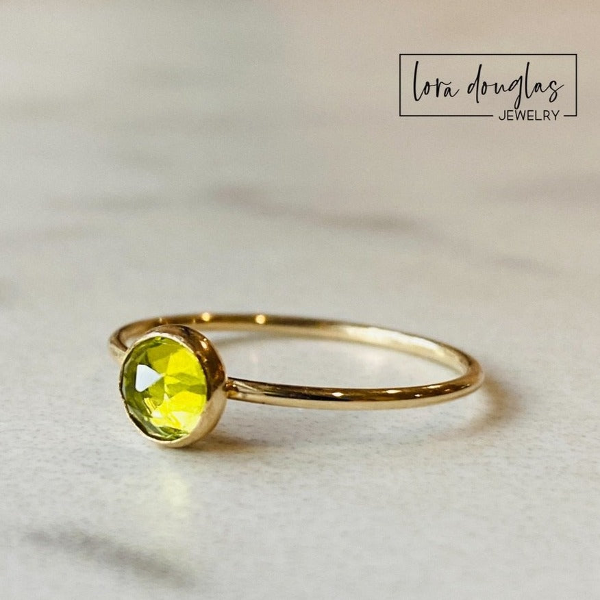 Natural peridot birthstone ring in US size 6 with a 5mm faceted rose cut green gemstone set in 14/20 gold filled, designed as a simple solitaire ring with a warm gold finish.
