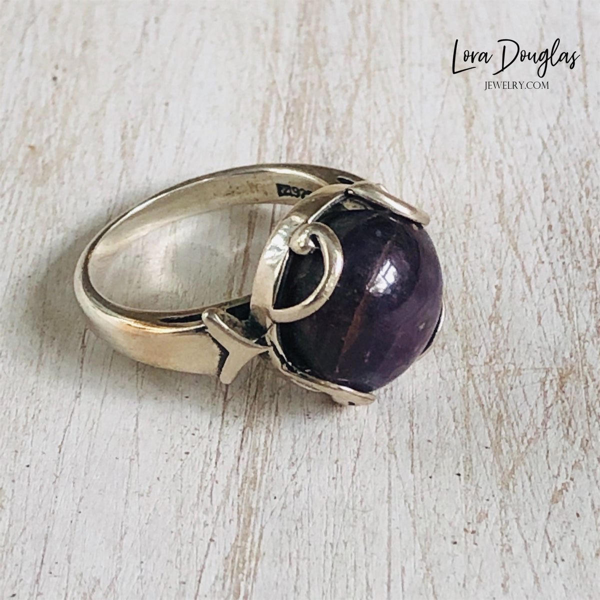 Natural ruby gemstone ring featuring a 12mm Purple India Ruby set in 925 sterling silver, shown in US size 7 with a bold purple stone that makes a distinctive choice for a July birthstone or gemstone gift.
