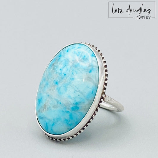 Natural turquoise ring featuring a substantial 26mm x 19mm blue gemstone set in sterling silver, shown as a finished US size 7 statement ring for shoppers looking for bold natural stone jewelry.
