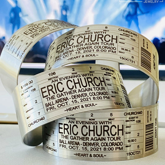 Personalized concert ticket bracelet in brushed stainless steel, custom engraved with artist, venue, date, section, row and seat details to create a wearable keepsake from a favorite live music event.
