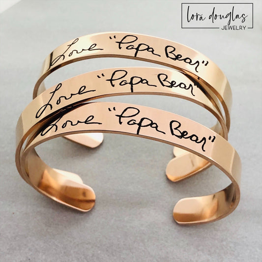 Personalized handwriting bracelet engraved with Mom's actual handwriting on a stainless steel cuff. A meaningful Mother's Day gift available in silver, gold, or rose gold, preserving handwritten words as a treasured family keepsake.