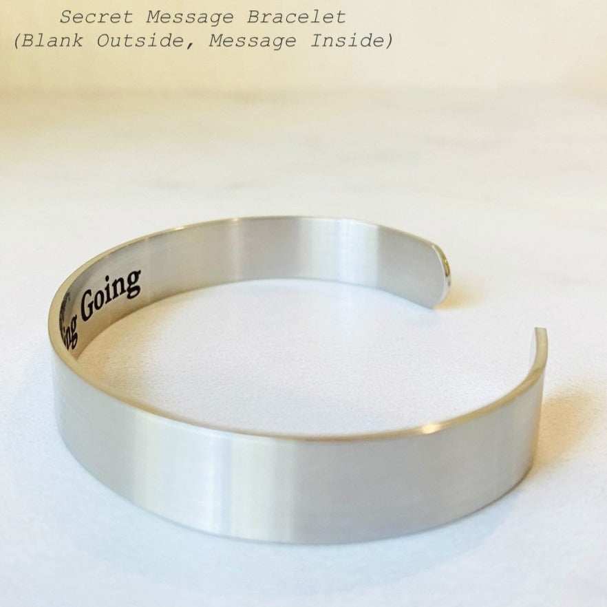 Personalized hidden message cuff bracelet with custom engraving concealed on the inside against the wrist and a clean blank exterior, available in silver, gold or rose gold stainless steel and three cuff widths.