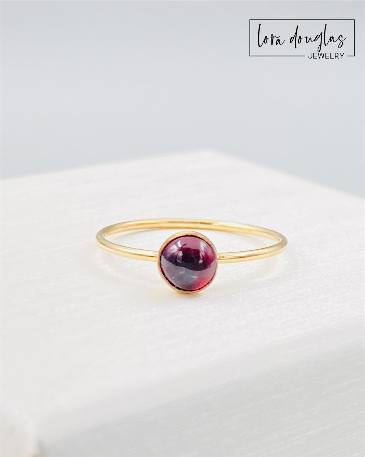 Petite garnet ring featuring a 5mm red gemstone in a classic gold filled solitaire design, a finished size 6 ring for shoppers looking for understated gemstone jewelry, a romantic gift or January birthstone ring.
