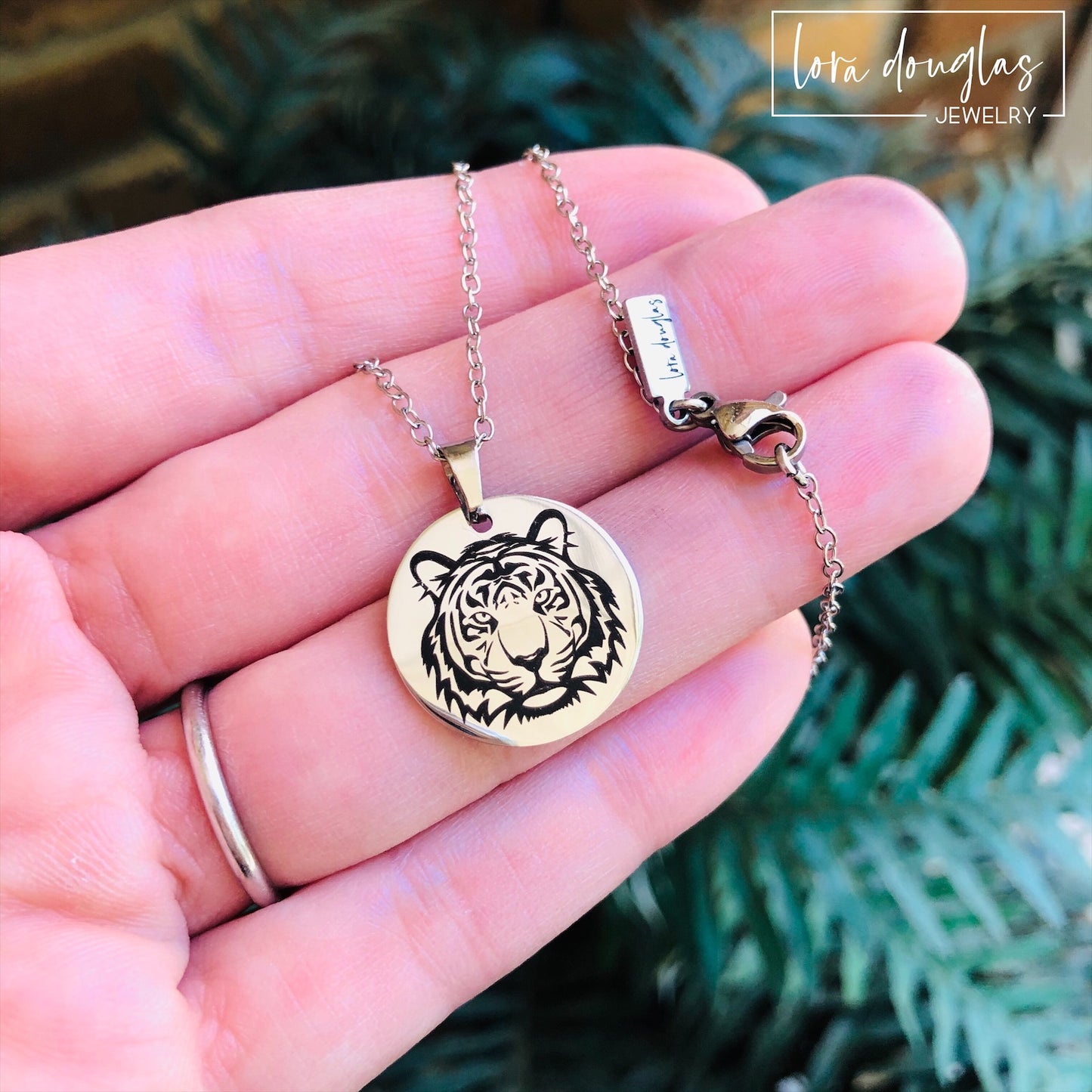 a necklace and a bracelet, featuring round pendants with a black and white tiger design on a silver-colored background.