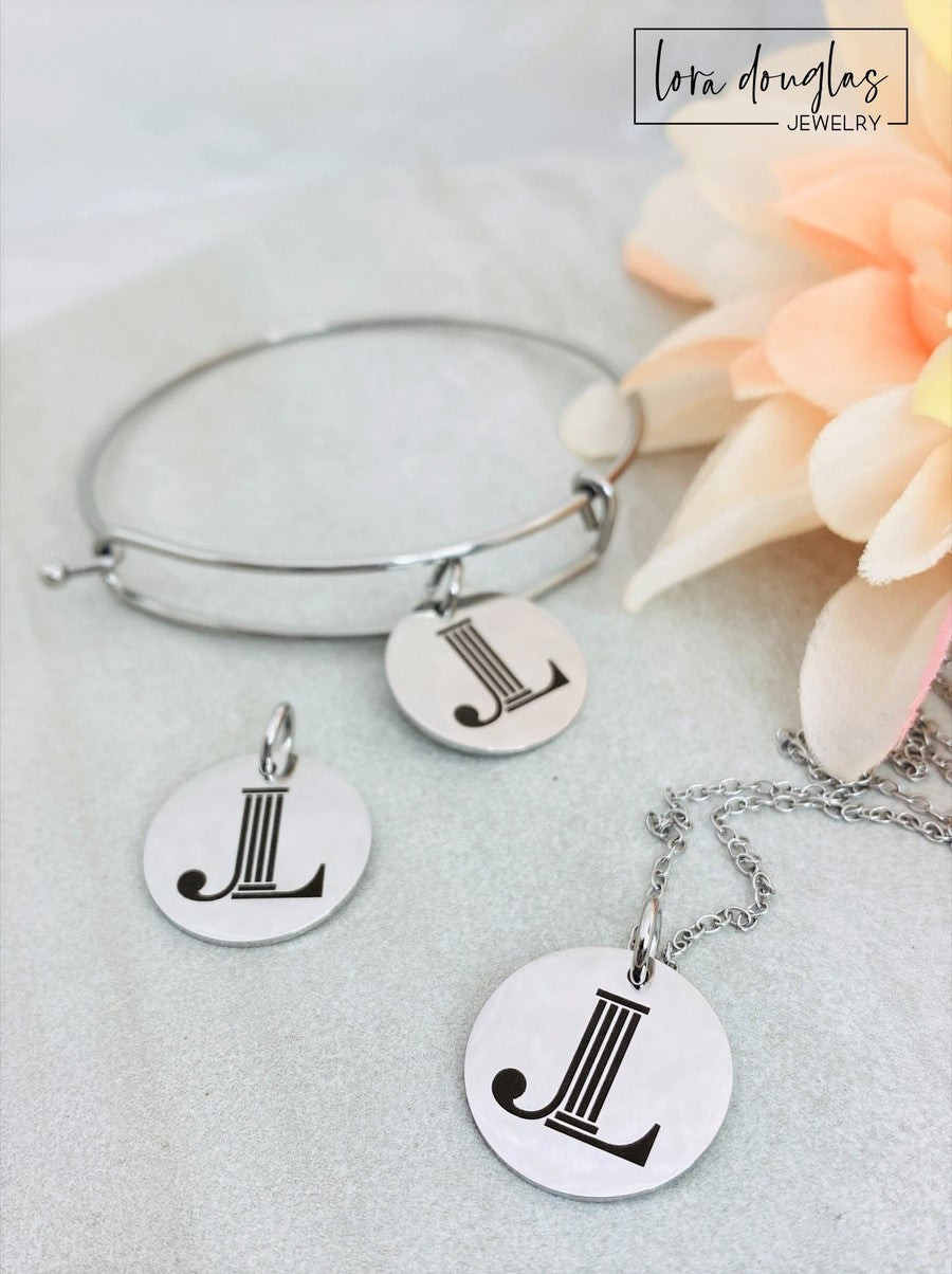Three custom jewelry charms with engraved logos on a disc-shaped pendant, attached to different types of jewelry including a necklace and a bracelet, with the option to engrave your logo.