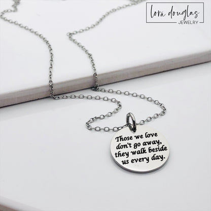 Silver necklace with a round pendant on a white background. Engraved with Those We Love Don't Go Away They Walk Beside Us Every Day.