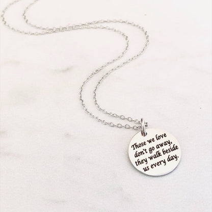 Silver necklace with a round pendant on a white background. Engraved with Those We Love Don't Go Away They Walk Beside Us Every Day.