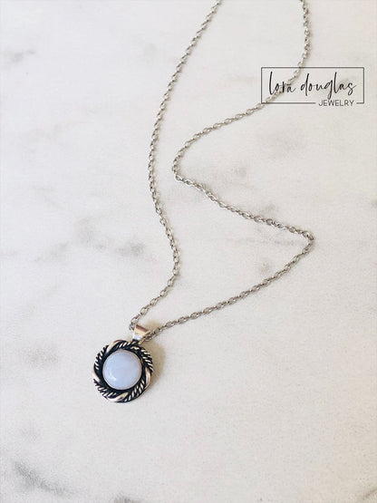 A sterling silver pendant necklace with a chalcedony stone set in a silver setting, attached to a sterling silver chain.