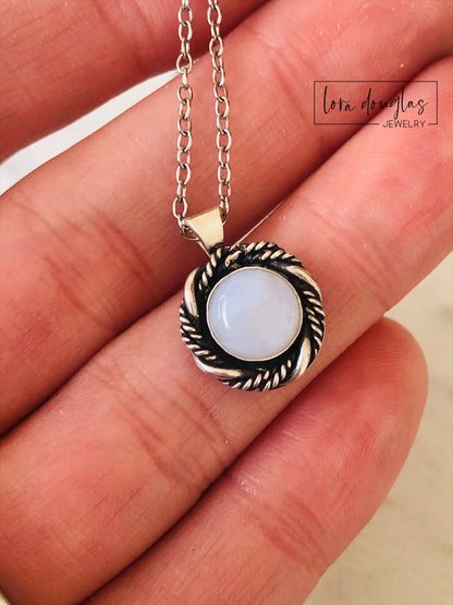A sterling silver pendant necklace with a chalcedony stone set in a silver setting, attached to a sterling silver chain.