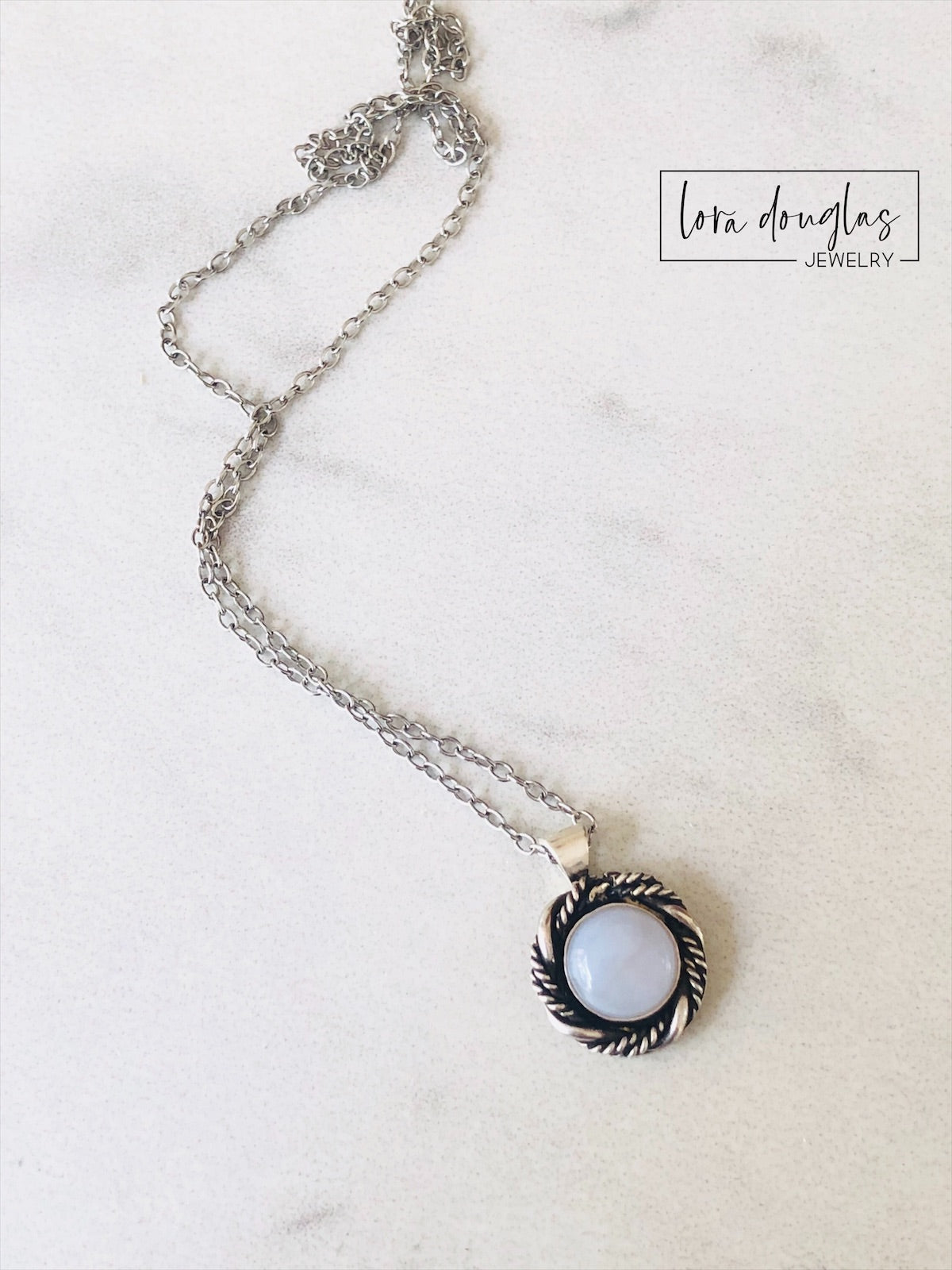 A sterling silver pendant necklace with a chalcedony stone set in a silver setting, attached to a sterling silver chain.