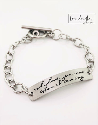 A stainless steel bracelet with engraved handwriting