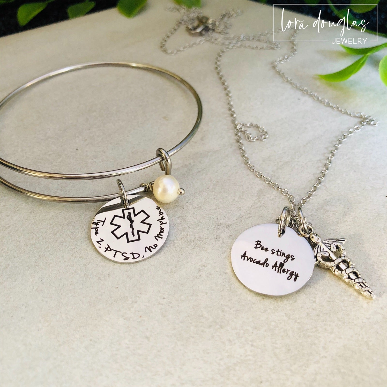 A stainless steel adjustable bangle bracelet with personalized medical alert charm.