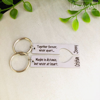 A stainless steel heart-shaped keychain with engraved text 'Together Forever Never Apart Maybe in Distance but Never at Heart' The keychain is silver-colored and has a personalized engraving.
