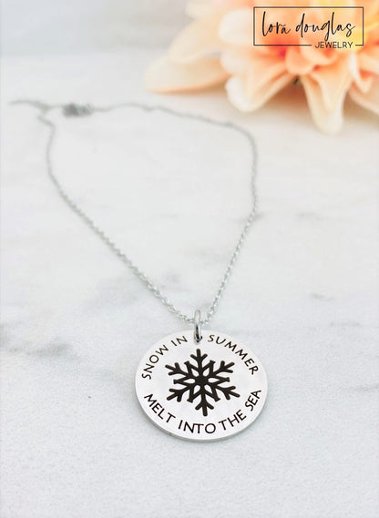 A collection of personalized jewelry items including necklaces, bracelets, and charms with engraved text and simple graphics on circular discs.