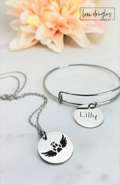 A collection of personalized jewelry items including necklaces, bracelets, and charms with engraved text and simple graphics on circular discs.