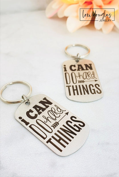 stainless steel keychains with the engraved text 'I CAN DO HARD THINGS' on a black background.