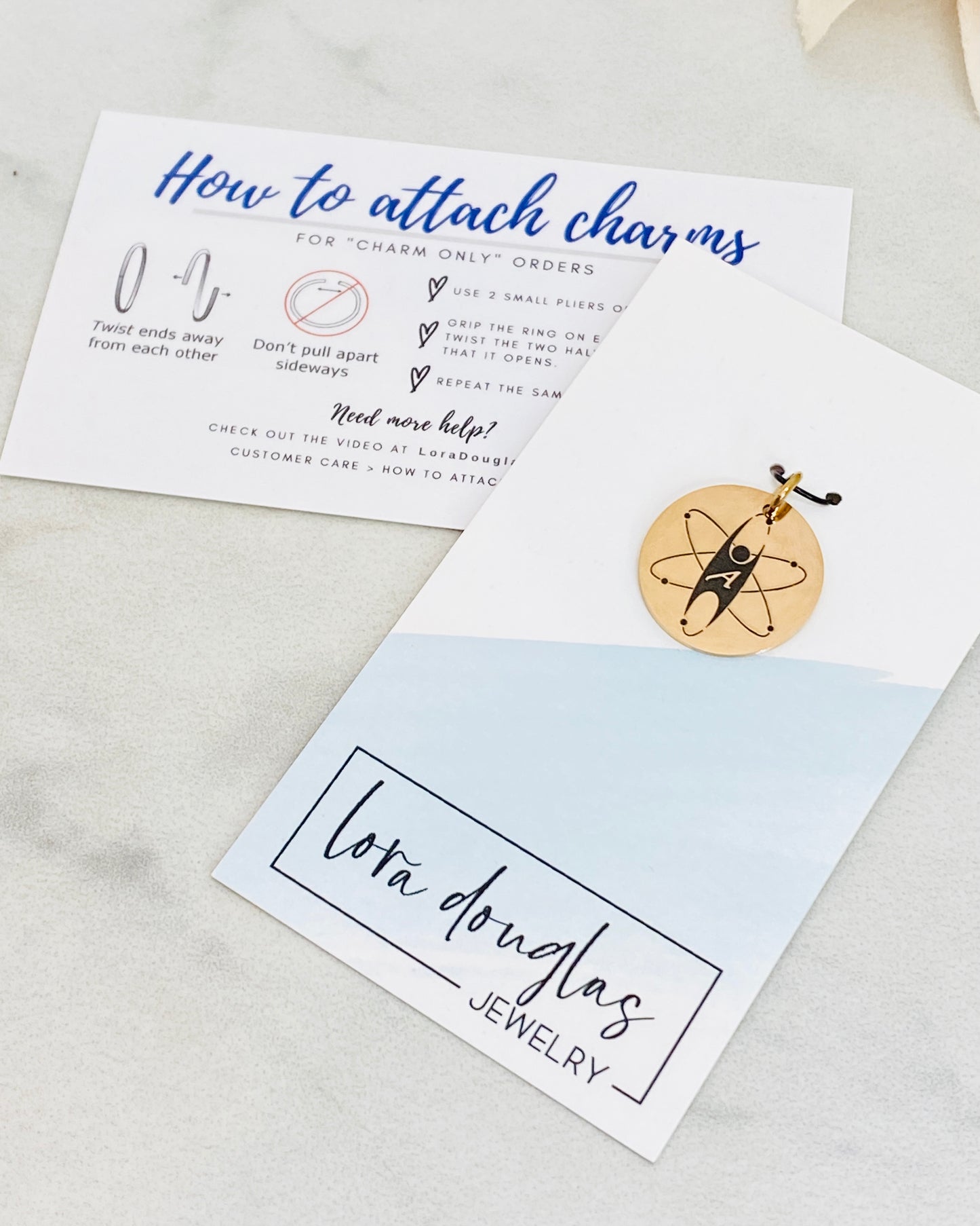 Three custom jewelry charms with engraved logos on a disc-shaped pendant, attached to different types of jewelry including a necklace and a bracelet, with the option to engrave your logo.