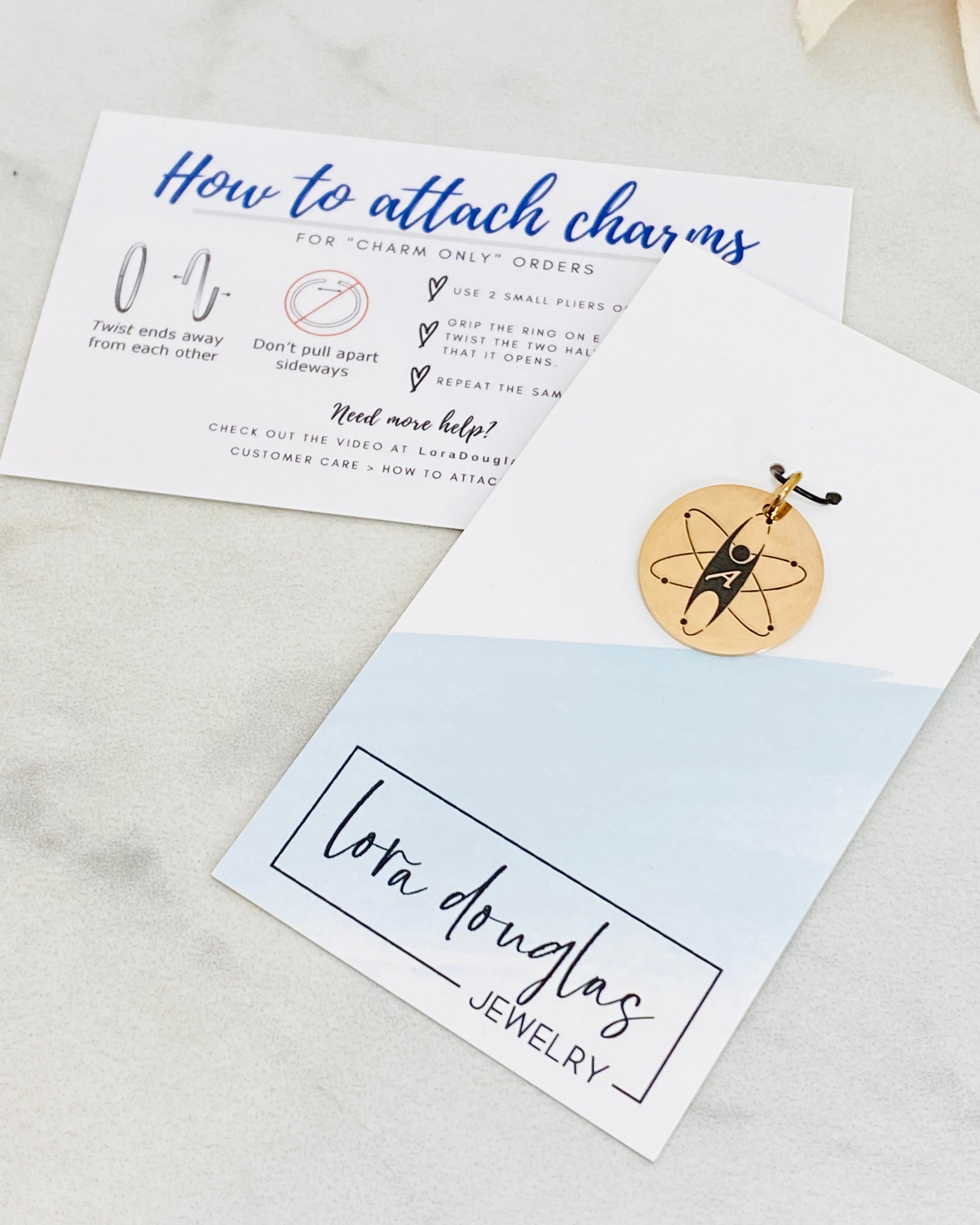 A collection of personalized jewelry items including necklaces, bracelets, and charms with engraved text and simple graphics on circular discs.