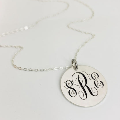 A silver monogram pendant necklace with a chain, displaying the letter R in a traditional script.