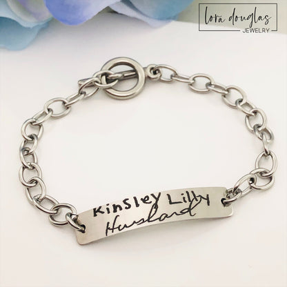 A stainless steel bracelet with engraved handwriting