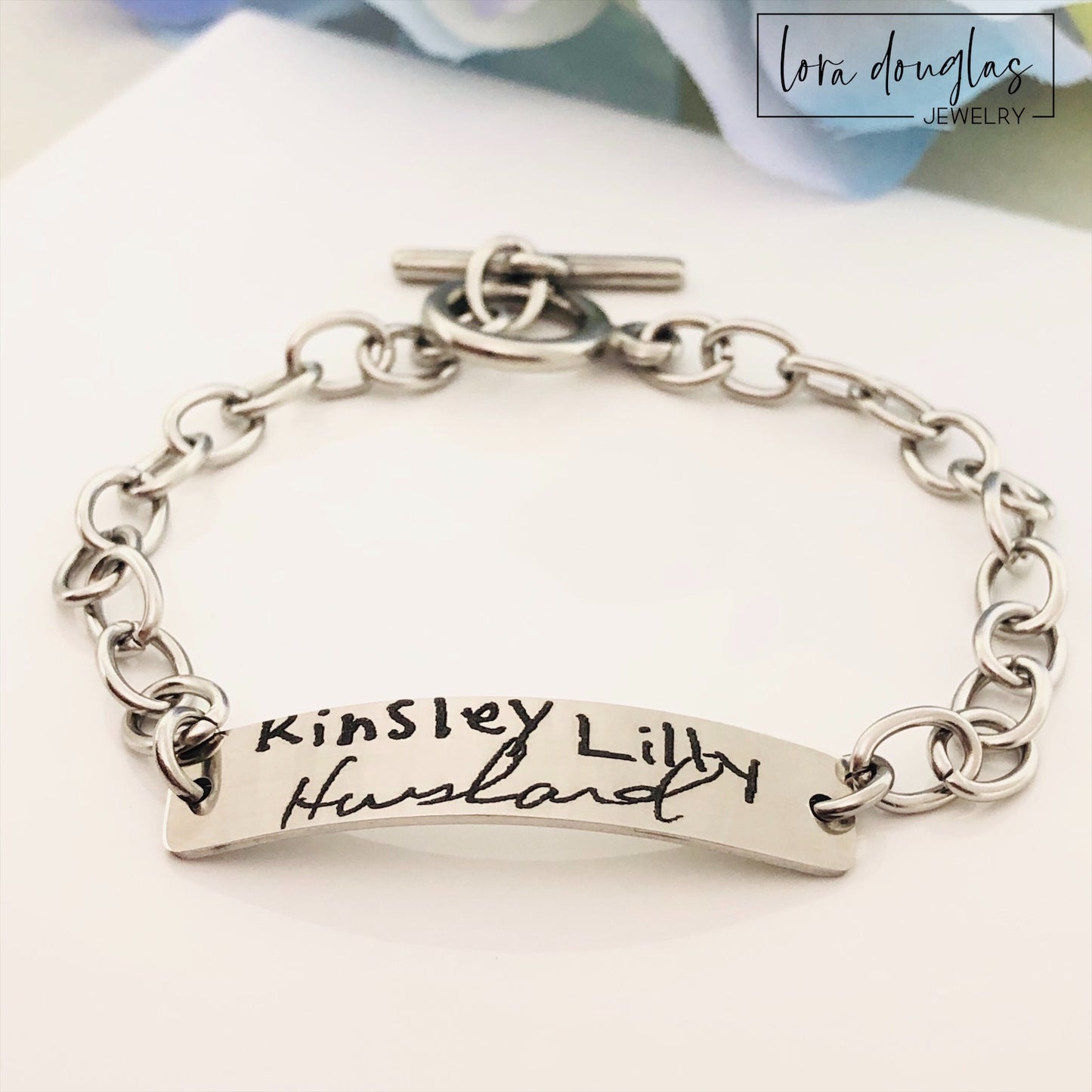 A stainless steel bracelet with engraved handwriting