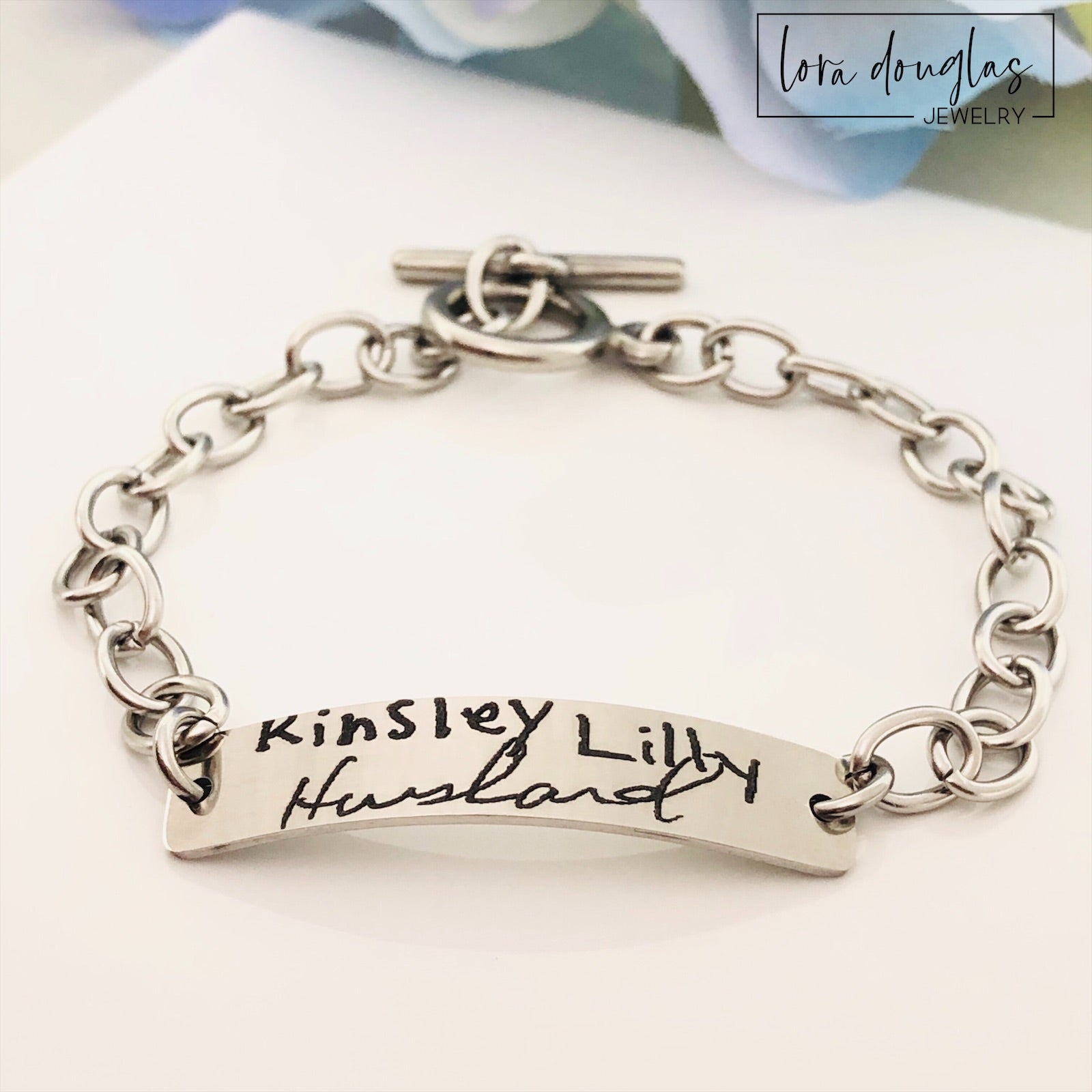 A stainless steel bracelet with engraved handwriting