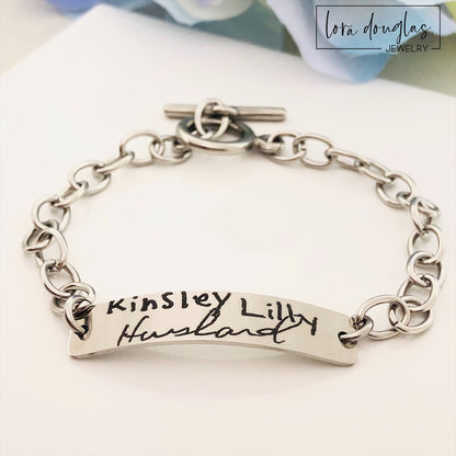 A stainless steel bracelet with engraved handwriting