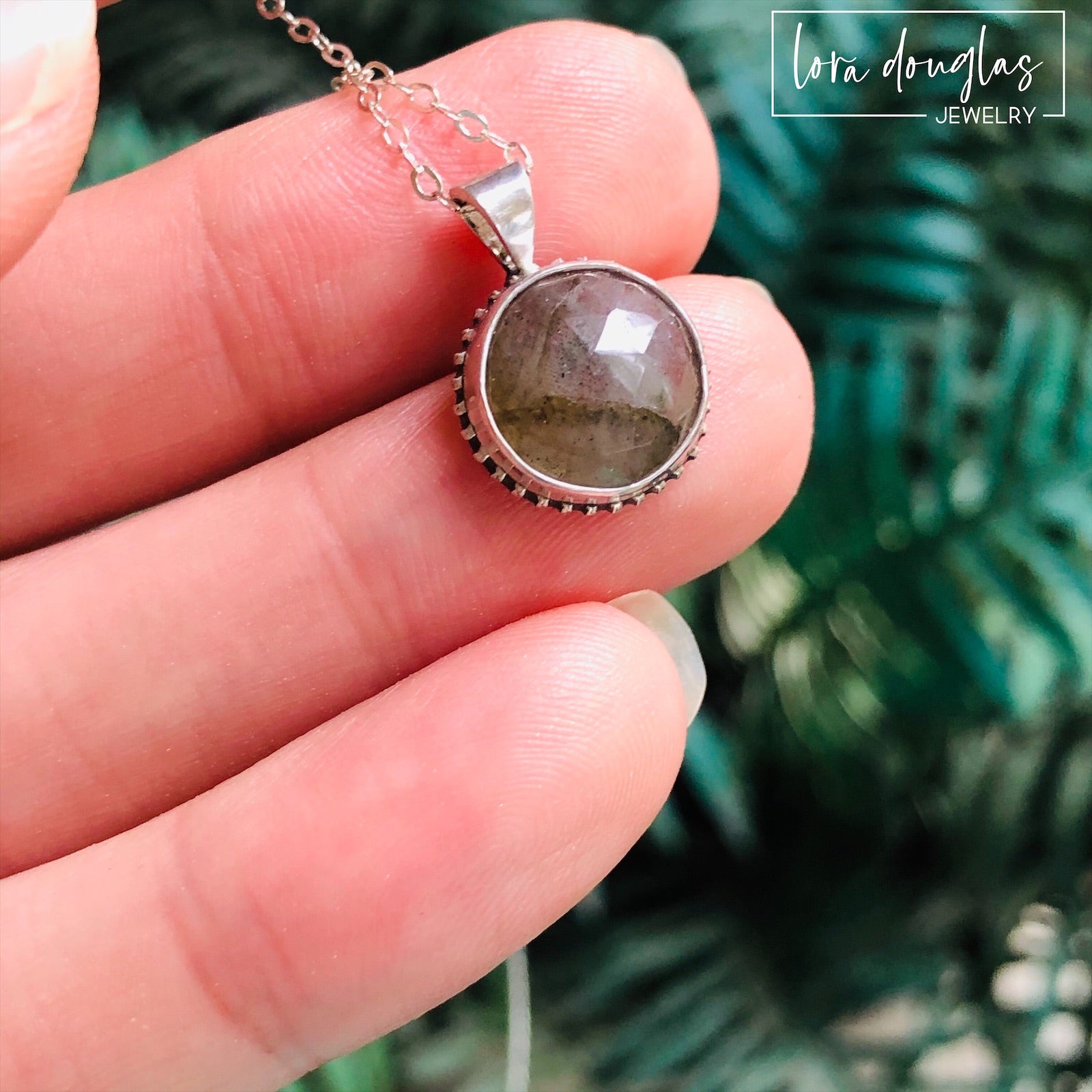 A sterling silver pendant necklace with a faceted labradorite gemstone in the center, attached to an 18-inch chain with a C clasp.