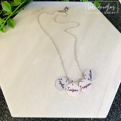 silver disc necklace with four round discs engraved with names