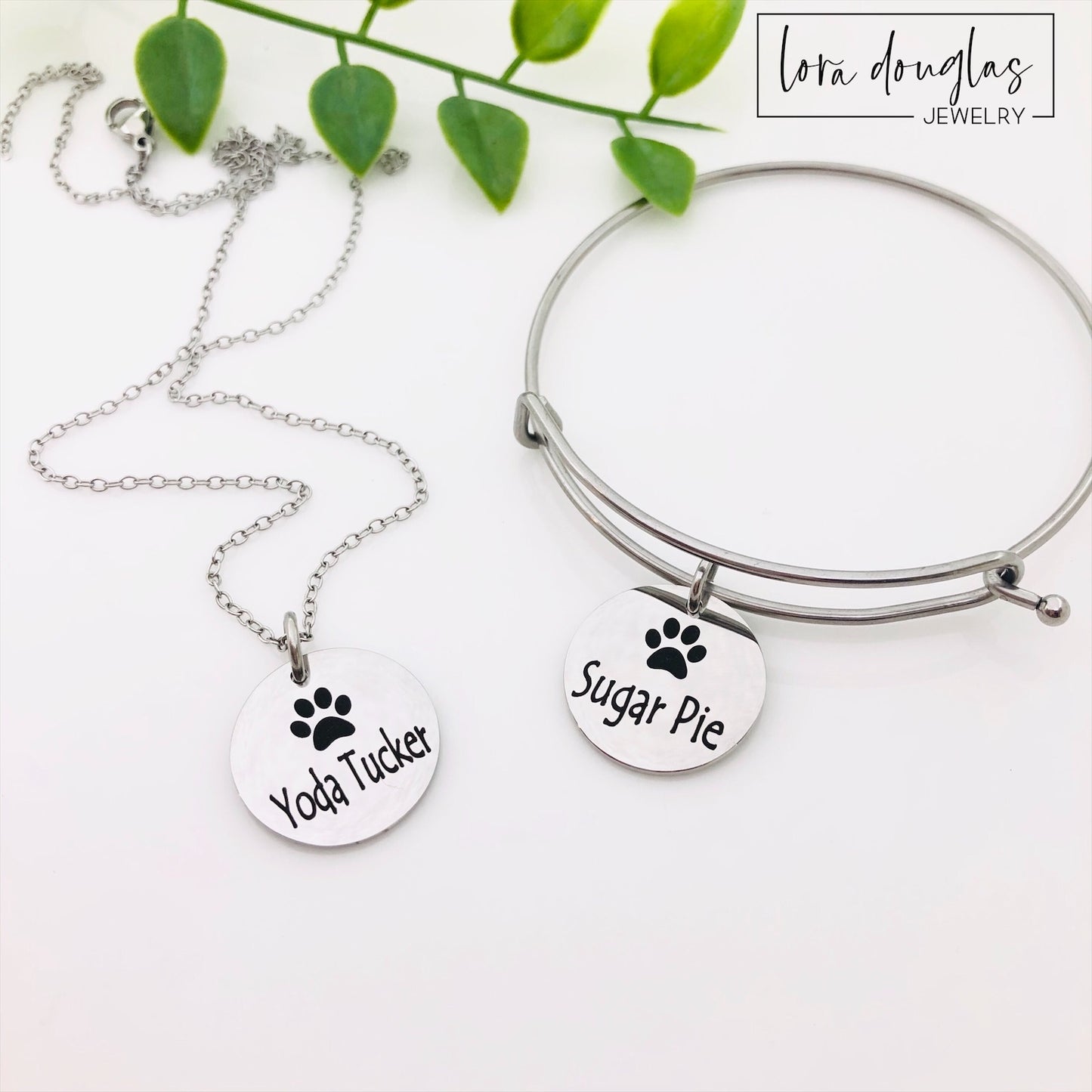 A stainless steel paw print necklace and bangle, with your pet's name engraved on them.
