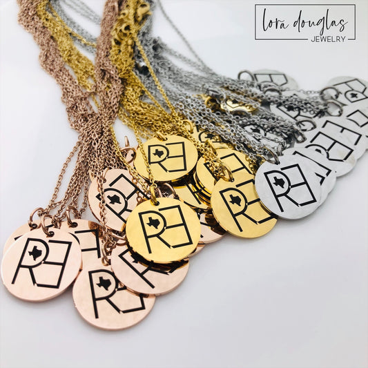 Three custom jewelry charms with engraved logos on a disc-shaped pendant, attached to different types of jewelry including a necklace and a bracelet, with the option to engrave your logo.