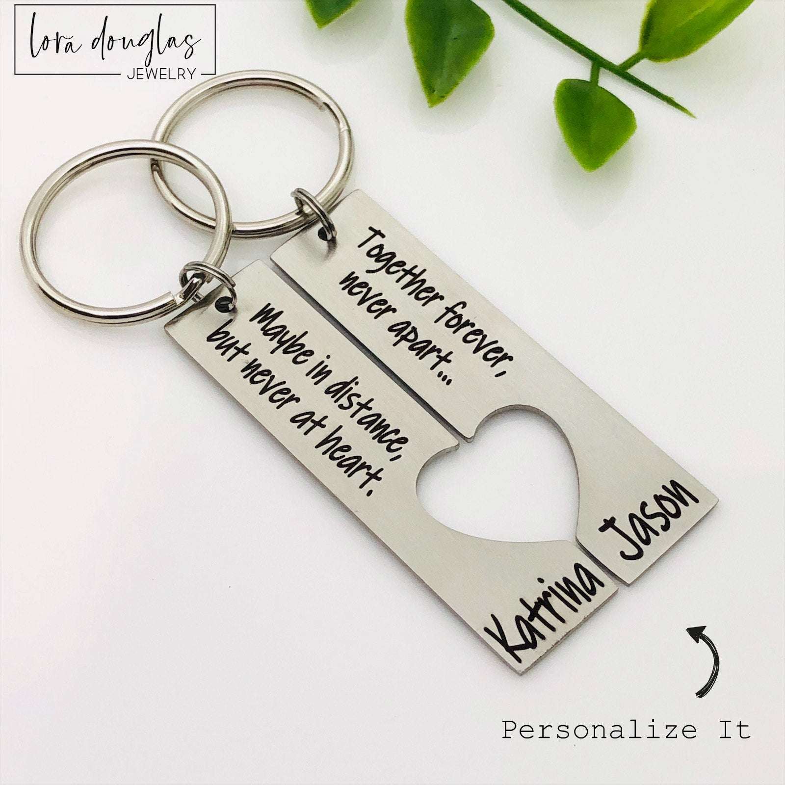 A stainless steel heart-shaped keychain with engraved text 'Together Forever Never Apart Maybe in Distance but Never at Heart' The keychain is silver-colored and has a personalized engraving.