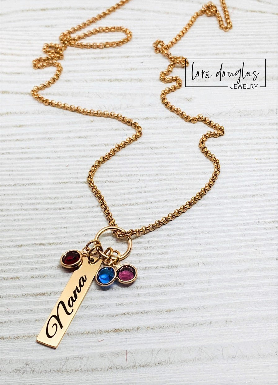 A rose gold birthstone necklace with a personalized engraving and a Swarovski Channel Plated Birthstone Charm.