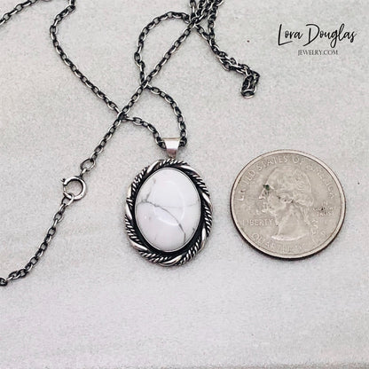 A sterling silver pendant necklace with a white howlite stone set in a silver setting, attached to an 18-inch sterling silver chain with a C clasp.